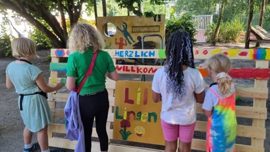 Kinder am selbst gestalteten Eingang der Kinderstadt Lil Lingen