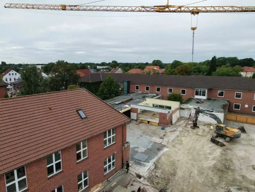 Baustelle am Gebäude mit Bauarbeiten und abgesperrtem Bereich.