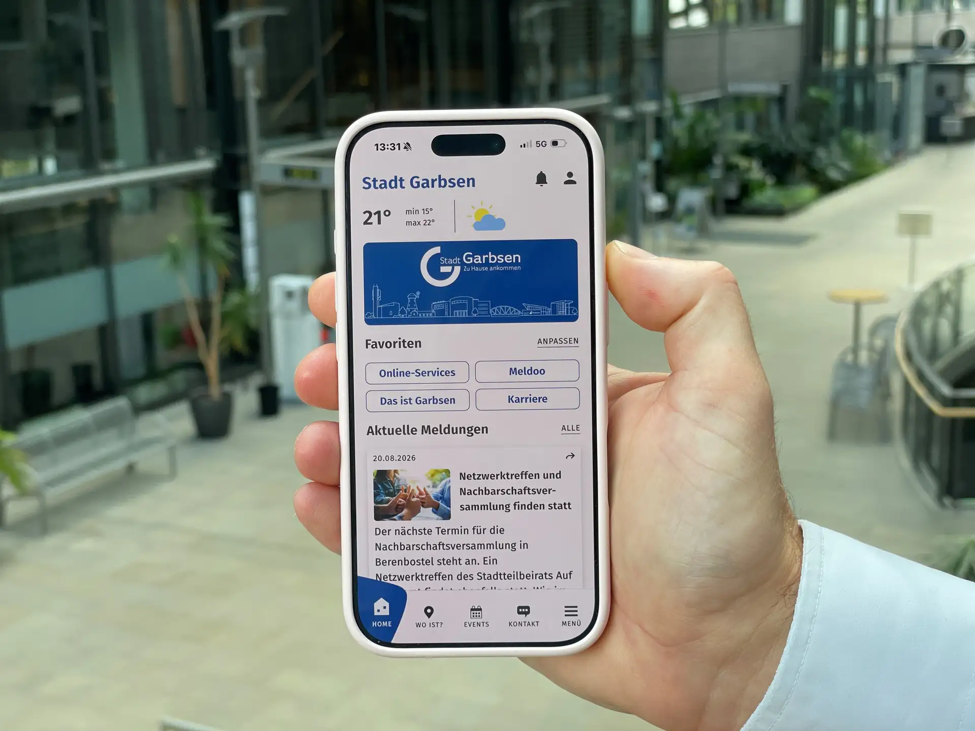 Smartphone mit App-Oberfläche, auf der die Stadt Garbsen und der Hinweis auf eigene Lieblingsorte in der MeinGarbsen-App angezeigt werden.